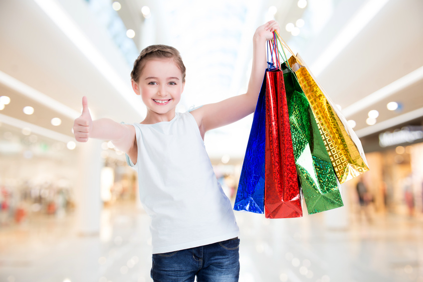 Pretty smiling little girl with shopping bags